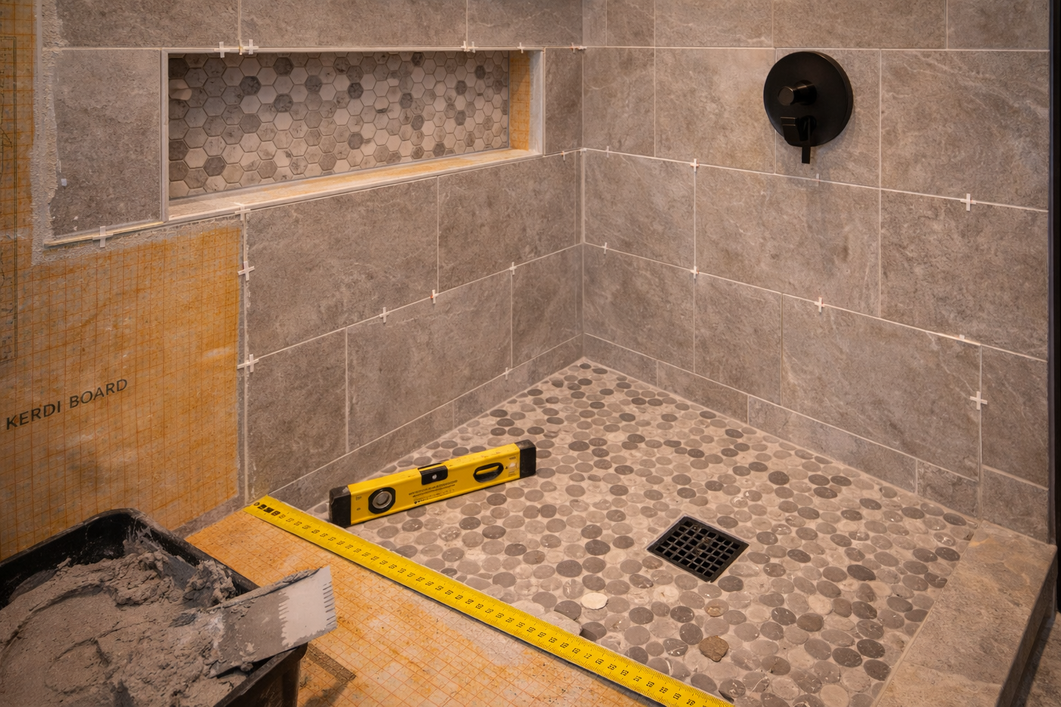 Shower tile installation with waterproofing layers, layout lines, drain slope, corner treatment, and trim finishing